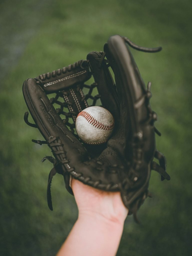 person-holding-baseball-ball-in-black-leather-baseball-mitt-qegsxvh9u9y
